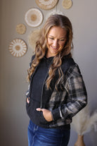 Black and grey plaid sleeve hoodie showing the hood drawstrings, long sleeves, and pouch pocket.