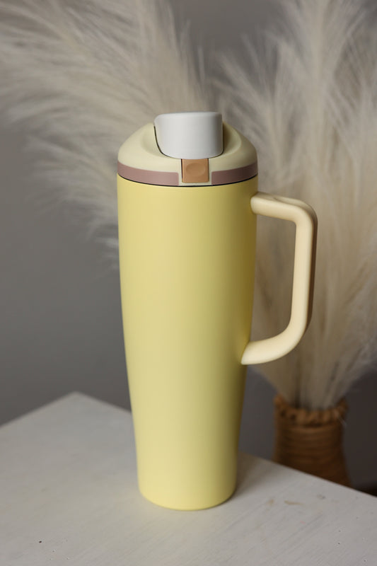 Yellow mug with a white handle on a light surface with a neutral background