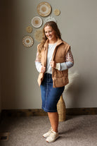 beige tan puffer vest oversized layered over a colorblock fall top with a denim skirt and sneakers