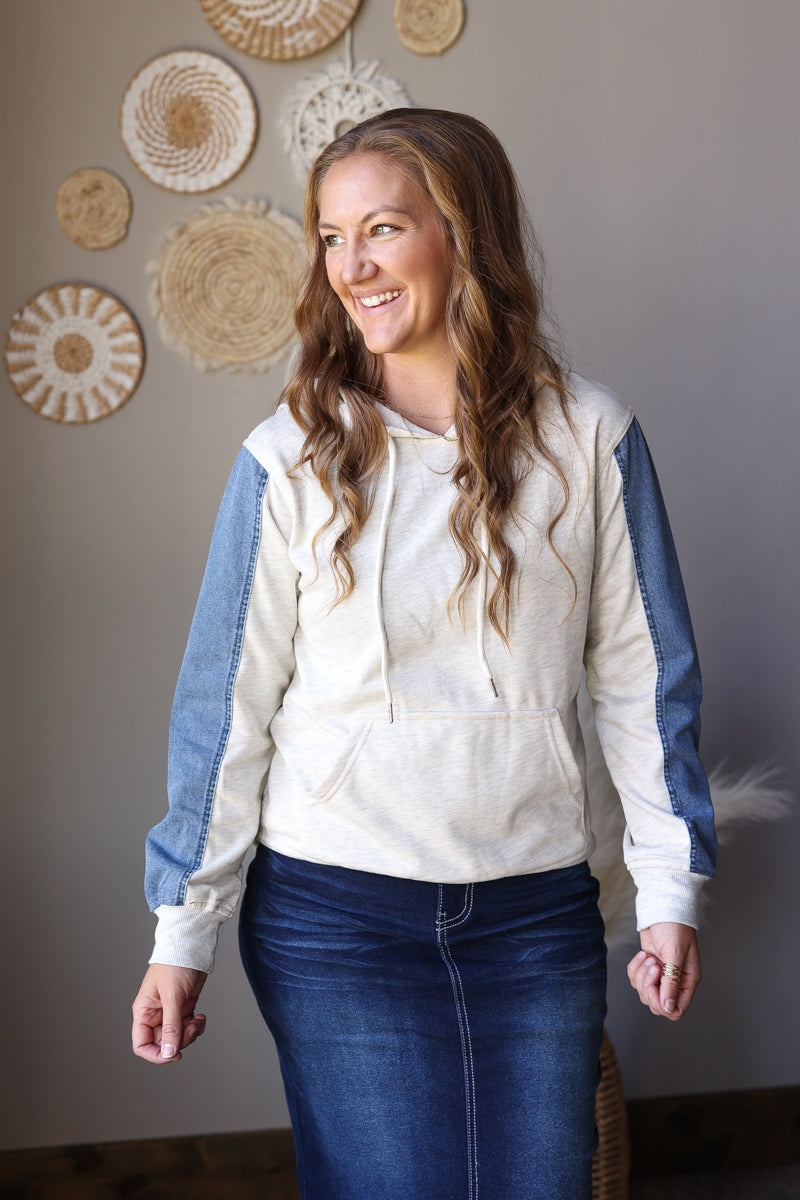 Light grey pullover hoodie showing blue sleeve panels, ribbed hem, and front pocket.