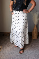 off white black polka dot maxi skirt with side slits paired with a black button up gauze top and sandals