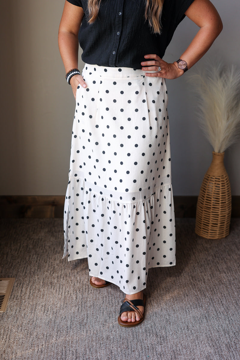 off white black polka dot maxi skirt with side slits paired with a black button up gauze top and sandals