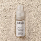 Kit-sch invisible dry shampoo bottle on a textured beige surface