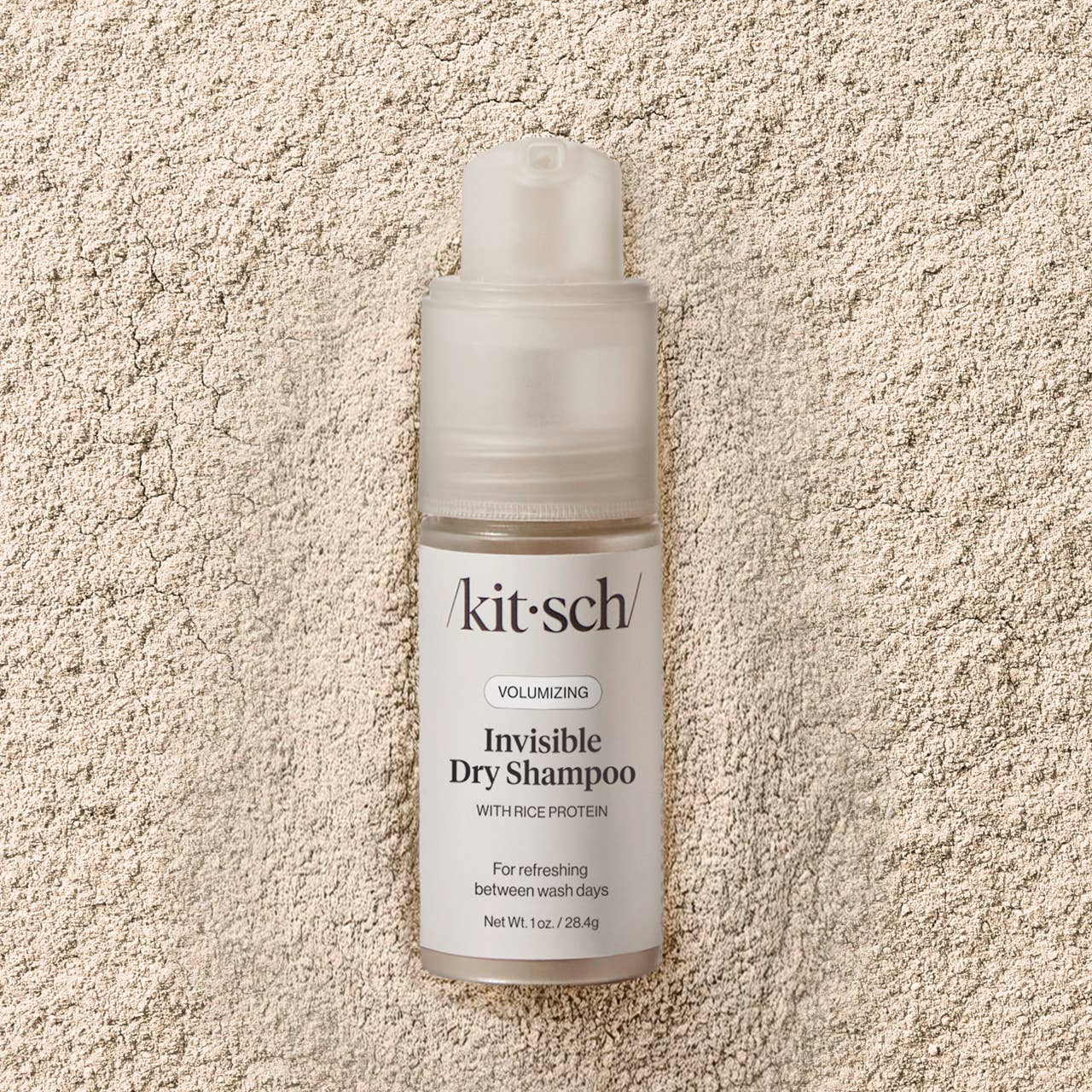 Kit-sch invisible dry shampoo bottle on a textured beige surface
