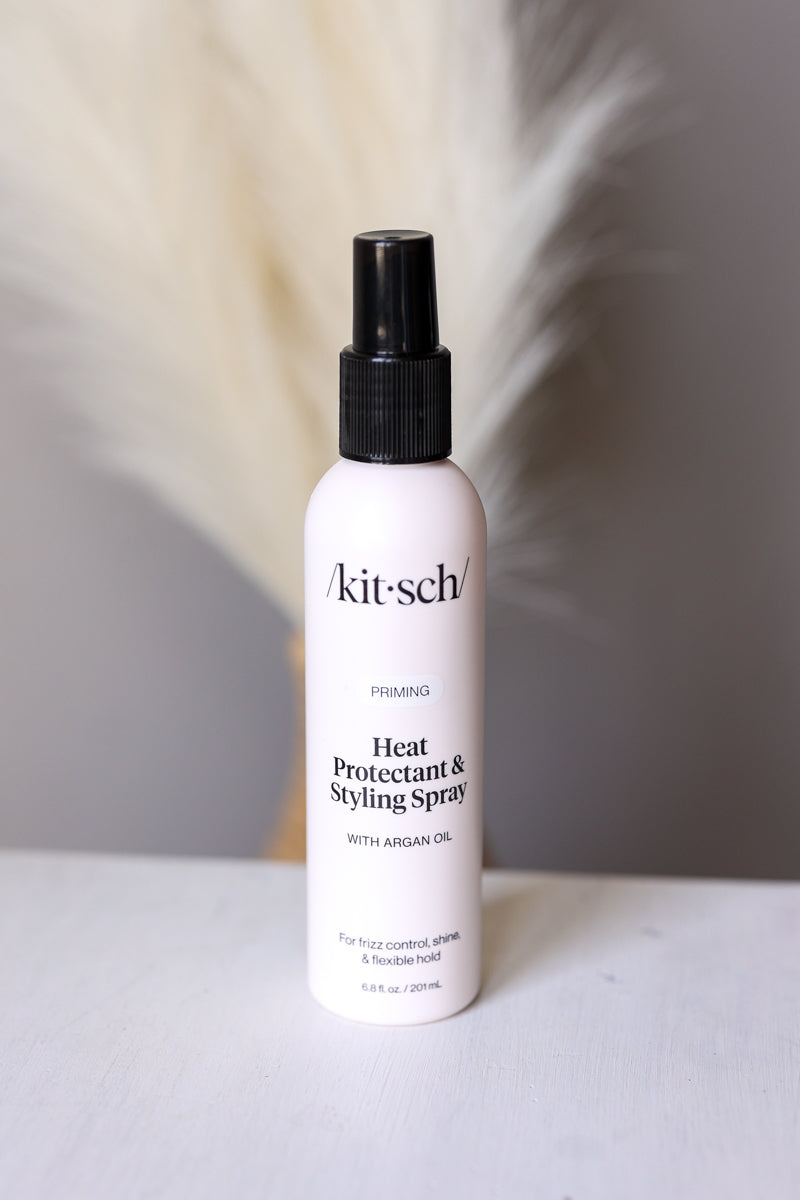 Kitsch heat protectant and styling spray bottle on a neutral background