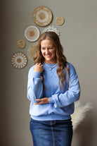 cornflower blue mineral wash crew sweatshirt with drop shoulders paired with a dark denim skirt