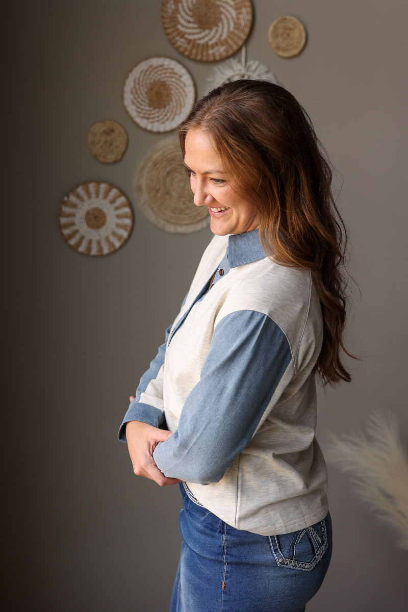 woman wearing a light grey and denim contrast henley top with midi denim skirt