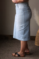 Light blue denim skirt worn by a person on a neutral background