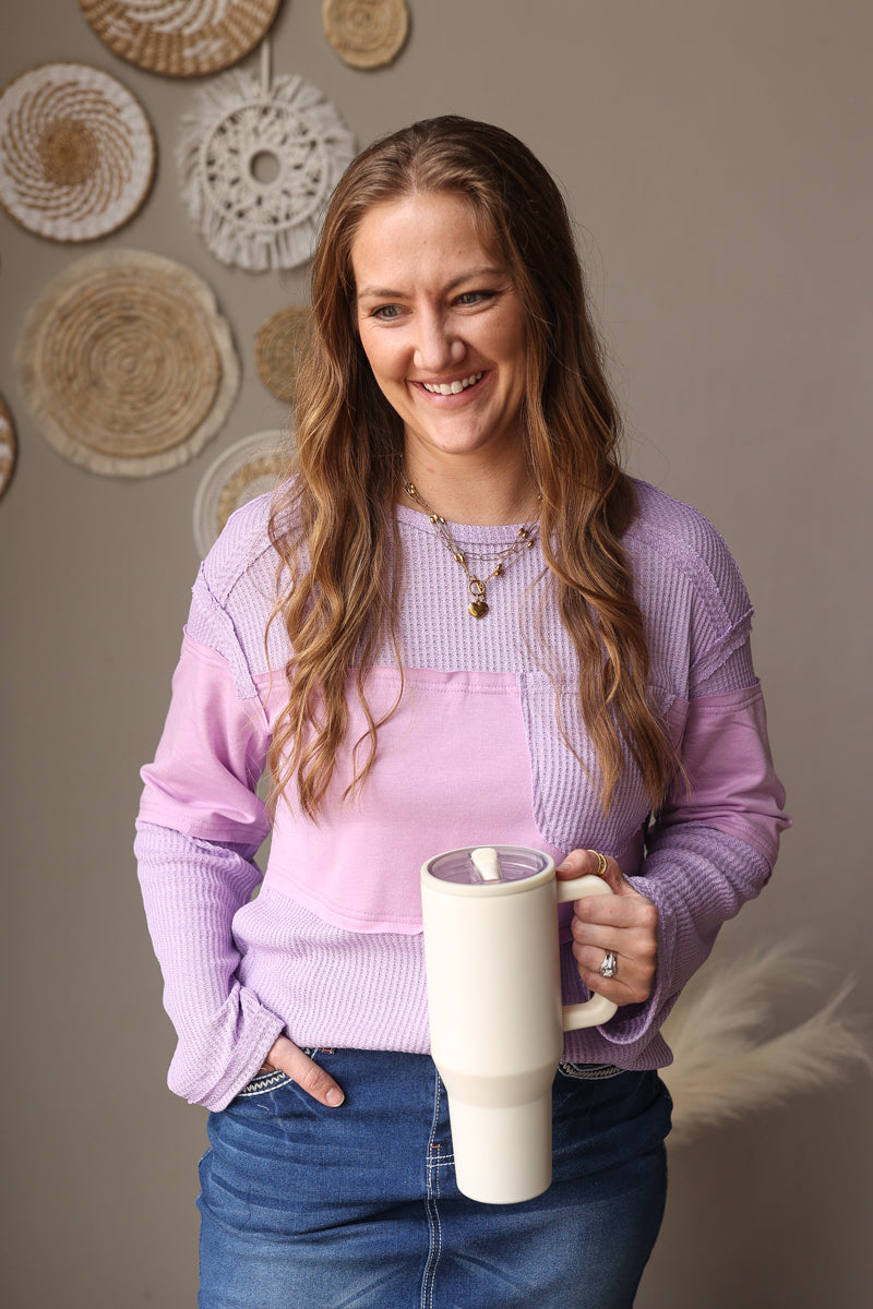 Woman holding a large mug indoors with decorative wall art in the background