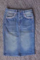 Front flat lay of a girls’ vintage wash denim midi skirt with faded blue denim, front pockets, belt loops, and a button waist.