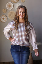 Front view of a brown and cream plaid top with striped sleeves, round neckline, and a denim skirt.