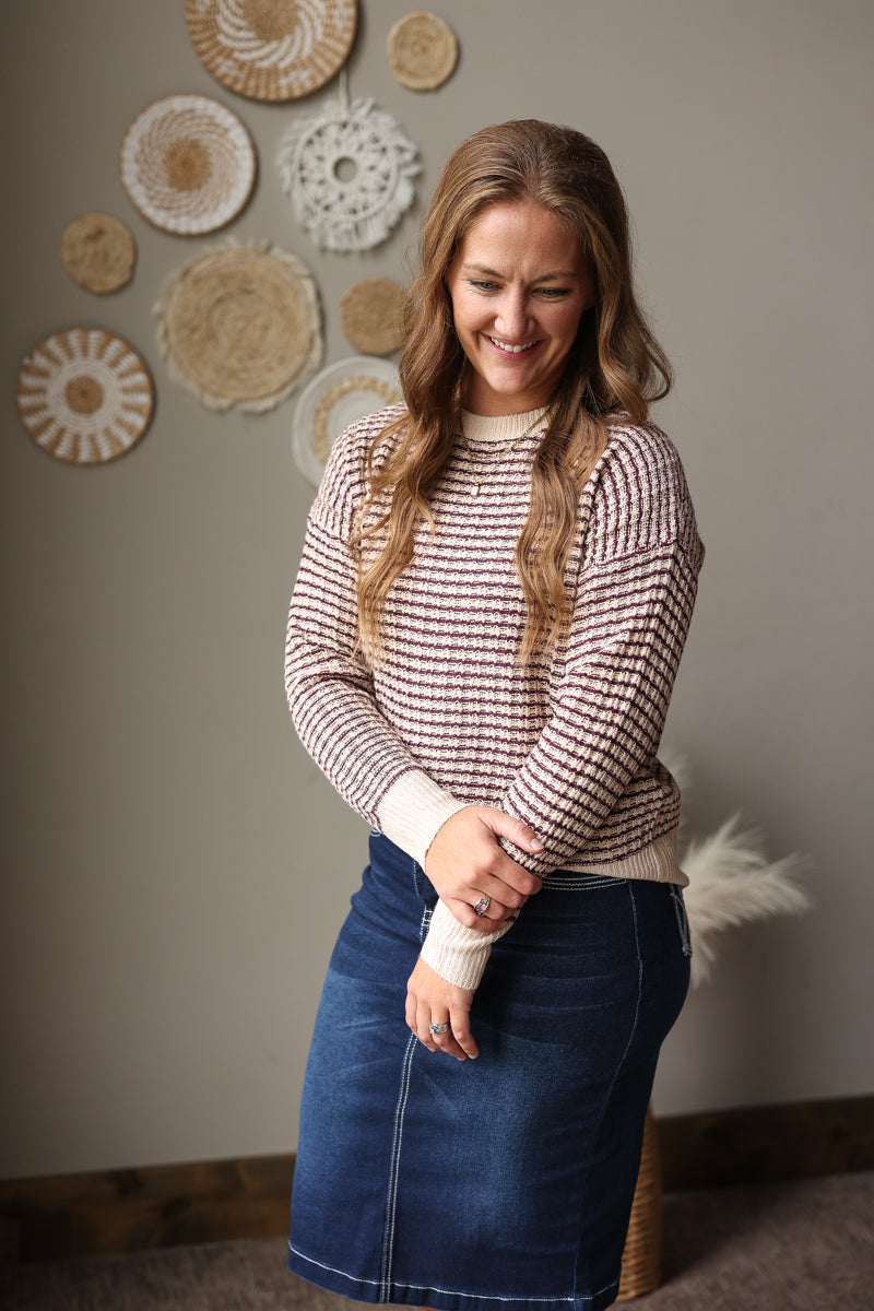mocha and burgundy checkered staccato sweater styled with a dark wash stretch denim midi skirt