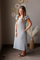 Woman wearing a striped dress standing in a room with decorative elements.