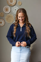 navy blue gold quarter zip sweatshirt top with light wash denim skirt