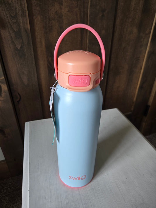 Light blue thermos with pink handle on a wooden surface