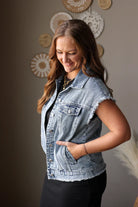 Woman wearing a denim vest with decorative plates on the wall behind her
