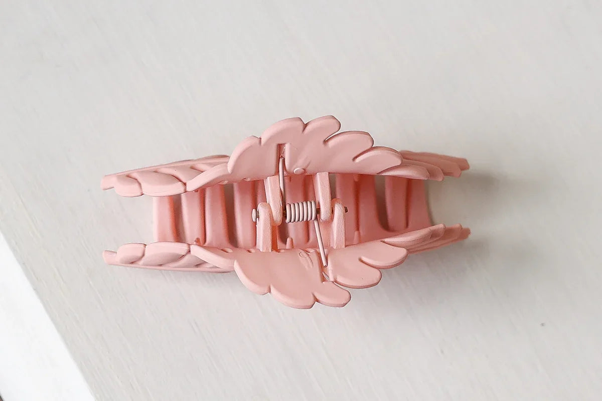 Pink hair clip on a light gray background