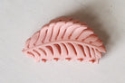 Pink leaf-shaped object on a white background