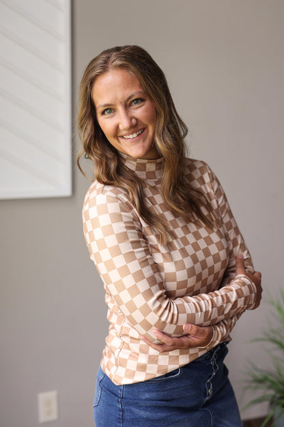 Woman wearing a checkered long-sleeve top and blue jeans denim skirt for fall/winter outfits.